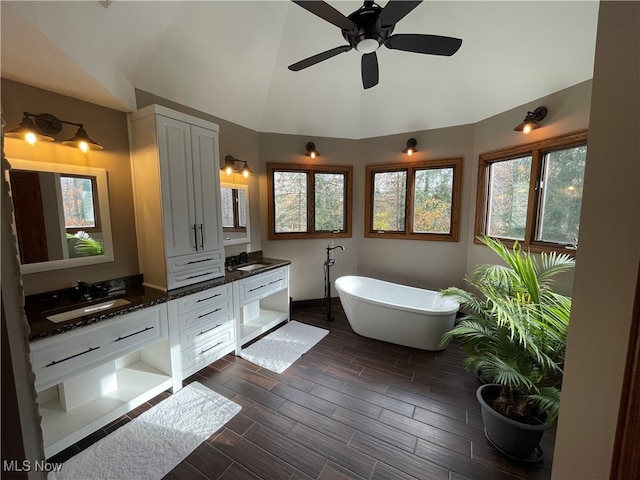 bathroom with vanity, lofted ceiling, ceiling fan, and a bathing tub