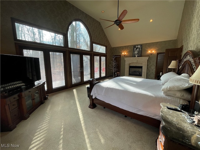 bedroom with ceiling fan, high vaulted ceiling, and light colored carpet