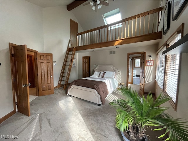 bedroom featuring high vaulted ceiling, beamed ceiling, multiple windows, and light colored carpet