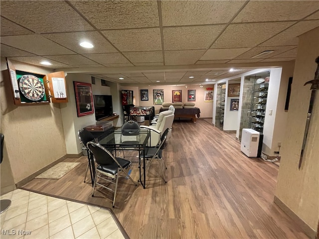 dining room with hardwood / wood-style flooring, a paneled ceiling, and built in shelves