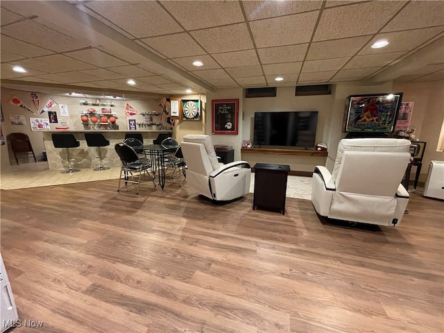 living room featuring hardwood / wood-style flooring and a paneled ceiling