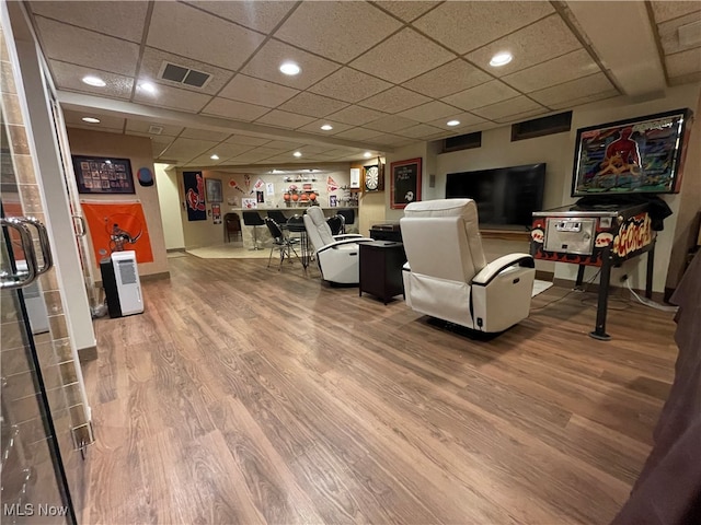 living room with a paneled ceiling and hardwood / wood-style flooring