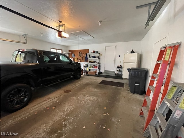 garage featuring white refrigerator and a garage door opener