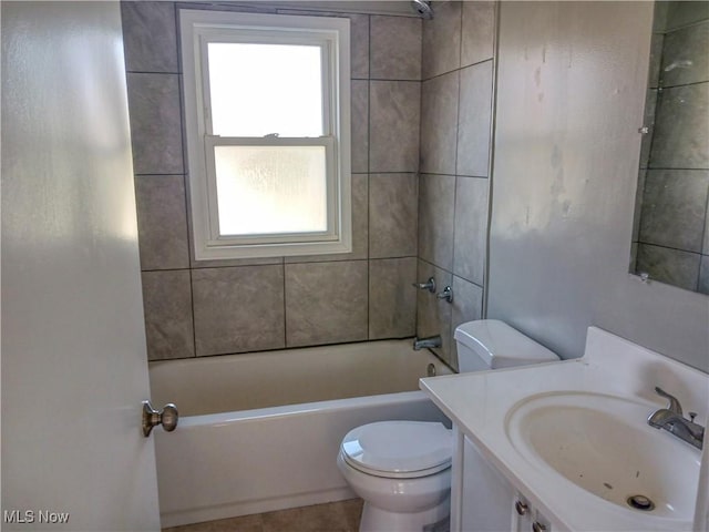 full bathroom featuring vanity, tile patterned flooring, tiled shower / bath, and toilet