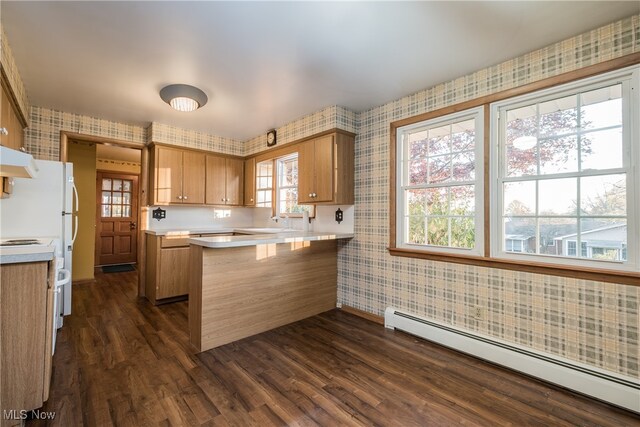 kitchen with kitchen peninsula, a breakfast bar area, plenty of natural light, a baseboard heating unit, and dark wood-type flooring