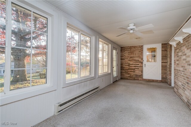 unfurnished sunroom featuring a wealth of natural light, ceiling fan, and a baseboard radiator