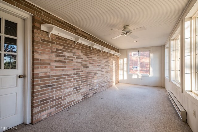 unfurnished sunroom with ceiling fan and a baseboard heating unit