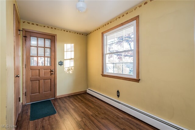 doorway featuring dark wood-type flooring and a baseboard heating unit