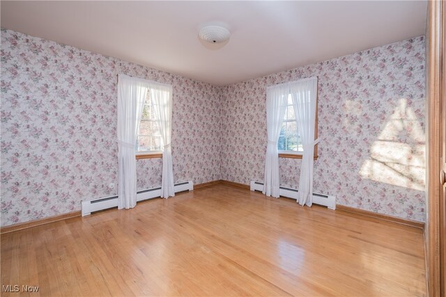 spare room with hardwood / wood-style flooring and baseboard heating