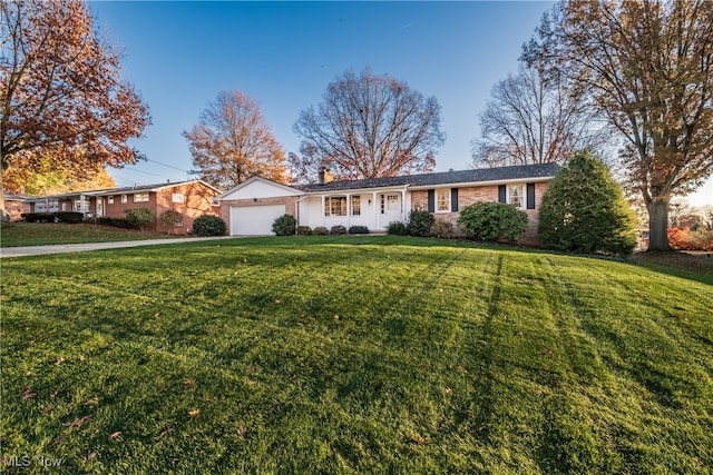 ranch-style home with a garage and a front yard