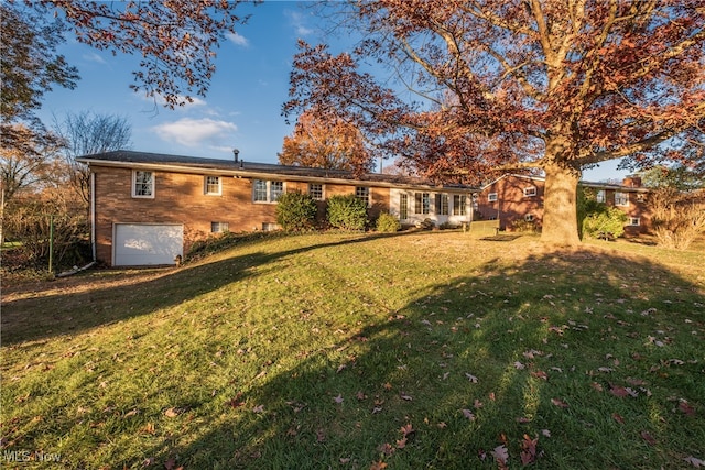 back of property with a lawn and a garage