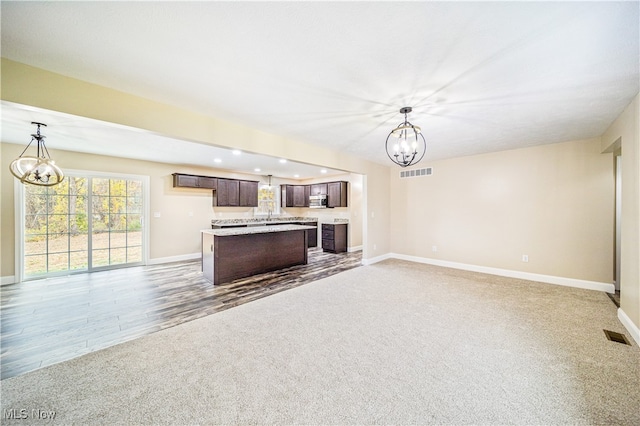 kitchen with decorative light fixtures, a notable chandelier, and wood-type flooring