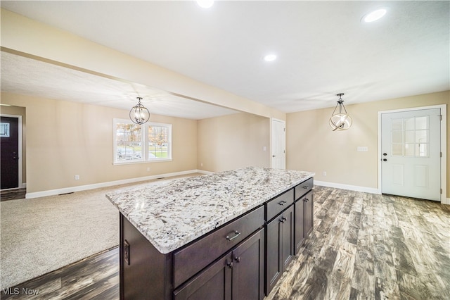 kitchen with hardwood / wood-style flooring, a notable chandelier, hanging light fixtures, dark brown cabinets, and a center island