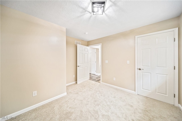 unfurnished bedroom with a textured ceiling and carpet floors