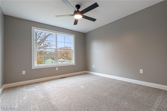 carpeted spare room with ceiling fan