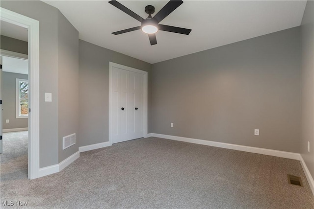 unfurnished bedroom with ceiling fan, light carpet, and a closet