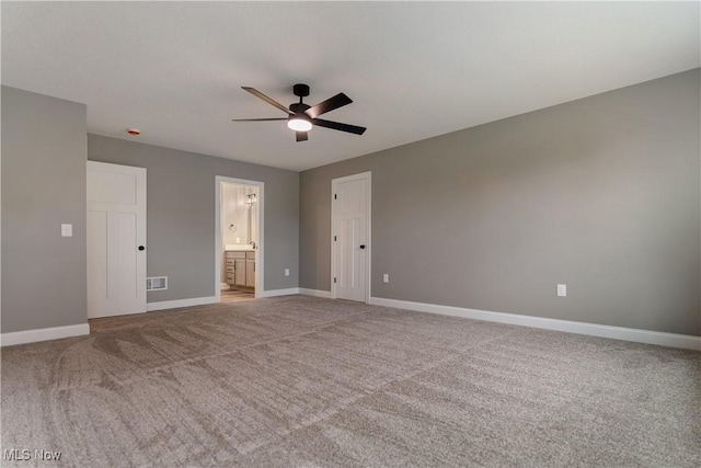 unfurnished bedroom with carpet, ceiling fan, and ensuite bath