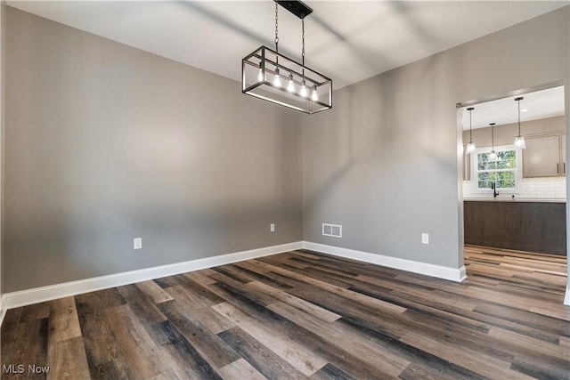 unfurnished dining area featuring dark hardwood / wood-style flooring