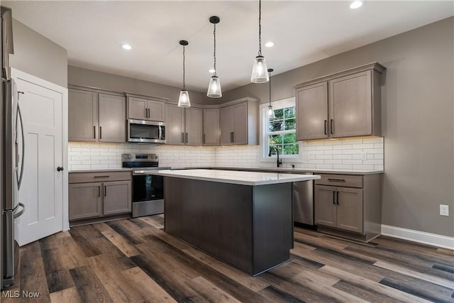 kitchen featuring a center island, dark hardwood / wood-style flooring, stainless steel appliances, and hanging light fixtures