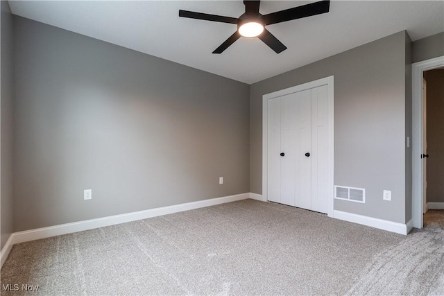 unfurnished bedroom with ceiling fan, a closet, and light carpet