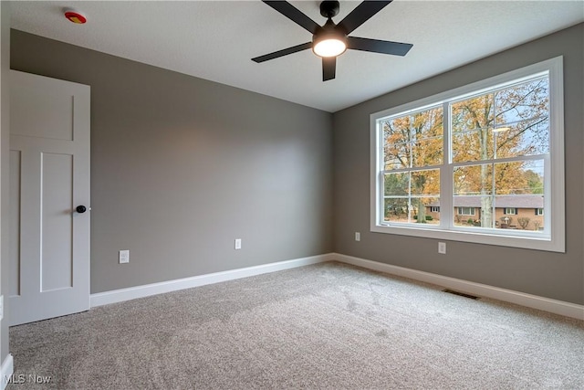 carpeted empty room featuring ceiling fan