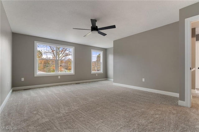 empty room with ceiling fan and light carpet