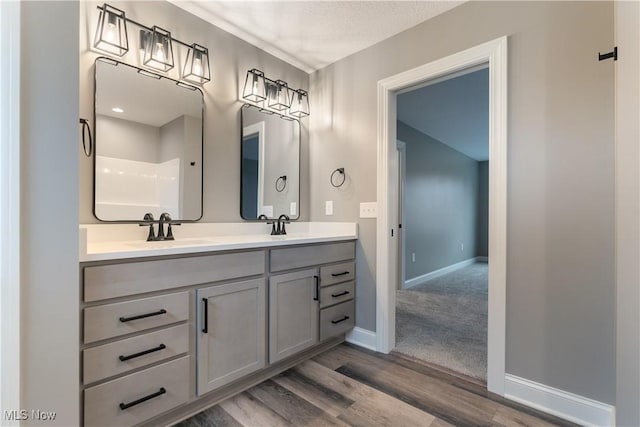 bathroom featuring walk in shower, vanity, a textured ceiling, and hardwood / wood-style flooring