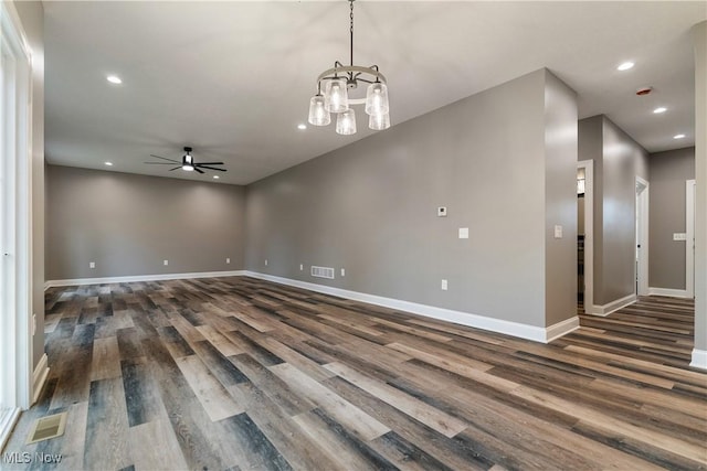 interior space with dark wood-type flooring and ceiling fan with notable chandelier