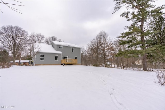 snow covered rear of property featuring a wooden deck