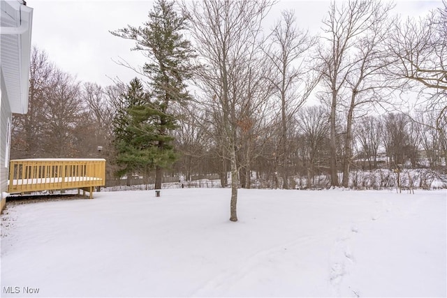 yard layered in snow featuring a deck