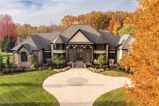 french country inspired facade featuring a front lawn