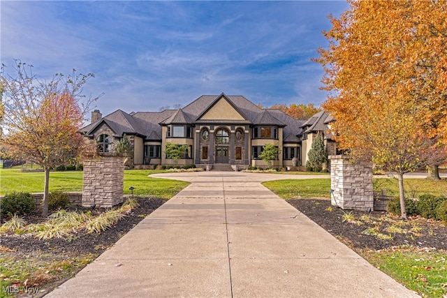 french provincial home with a front yard