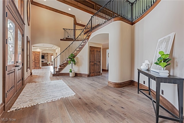 foyer featuring high vaulted ceiling, light hardwood / wood-style floors, and a healthy amount of sunlight