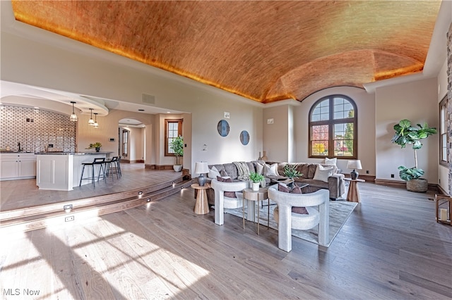 living room with brick ceiling, wood-type flooring, sink, and lofted ceiling