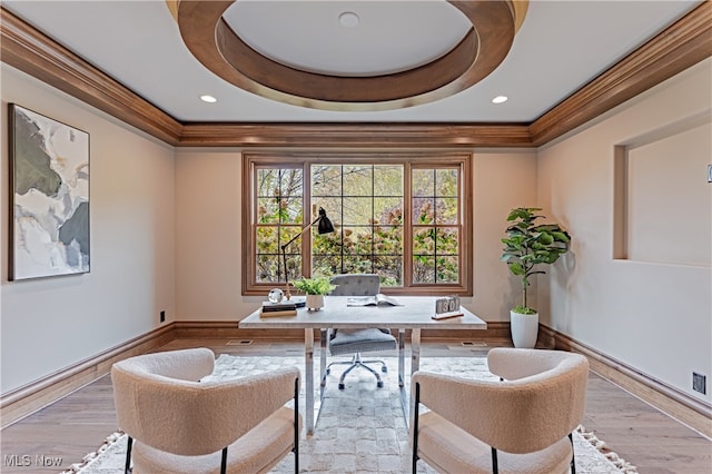 home office with light hardwood / wood-style flooring, crown molding, and a tray ceiling