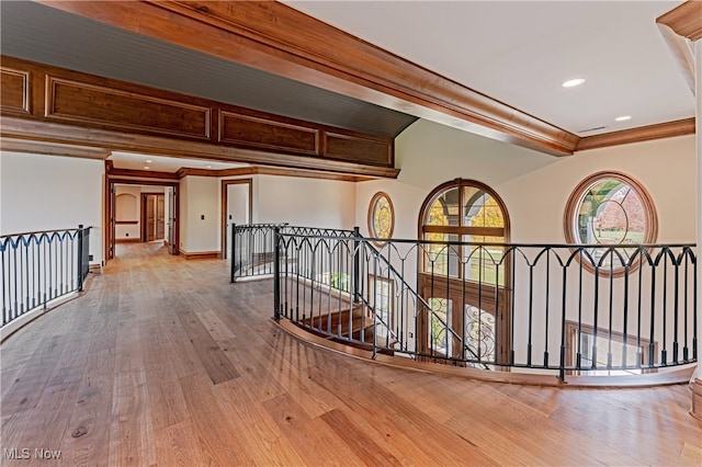 hallway featuring wood-type flooring, crown molding, and beam ceiling