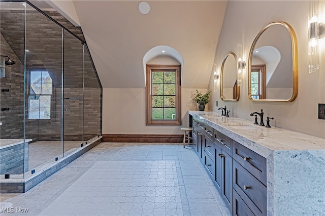 bathroom featuring vanity, vaulted ceiling, and a shower with door