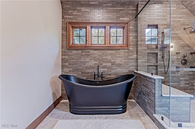 bathroom with brick wall and shower with separate bathtub