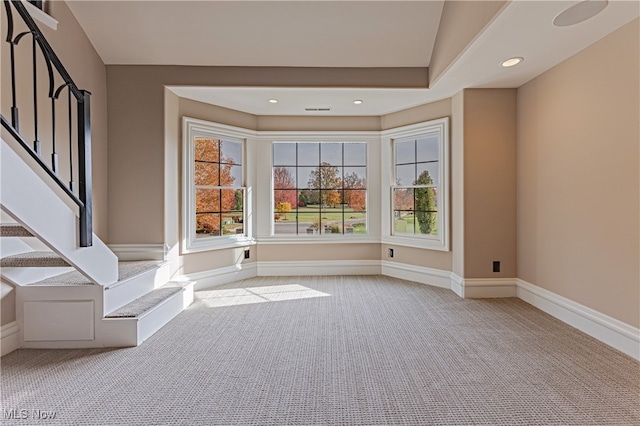 empty room featuring vaulted ceiling and light colored carpet