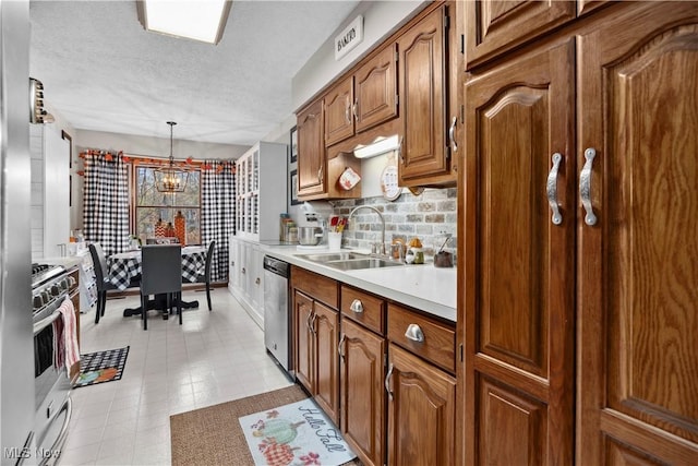 1284 Laurel Dr, West Salem, OH 44287 - kitchen featuring a sink, appliances with stainless steel finishes, light countertops, a chandelier, and brown cabinets