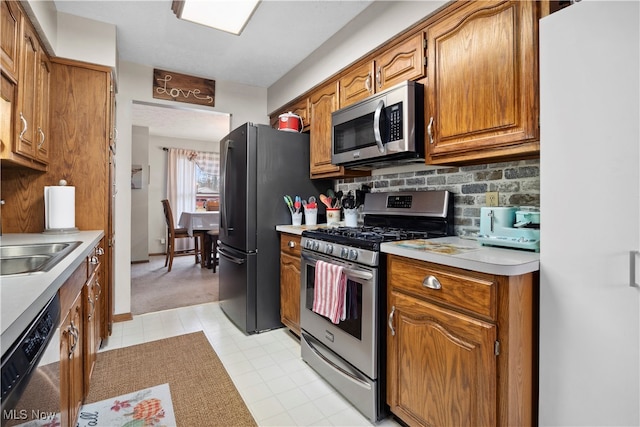 kitchen featuring decorative backsplash, sink, and stainless steel appliances