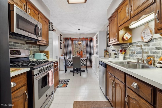 1284 Laurel Dr, West Salem, OH 44287 - kitchen with appliances with stainless steel finishes, a chandelier, a sink, light countertops, and backsplash