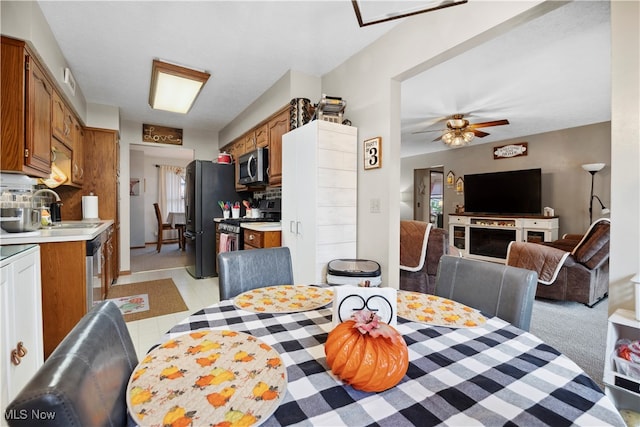 dining area featuring ceiling fan, sink, and light tile patterned flooring