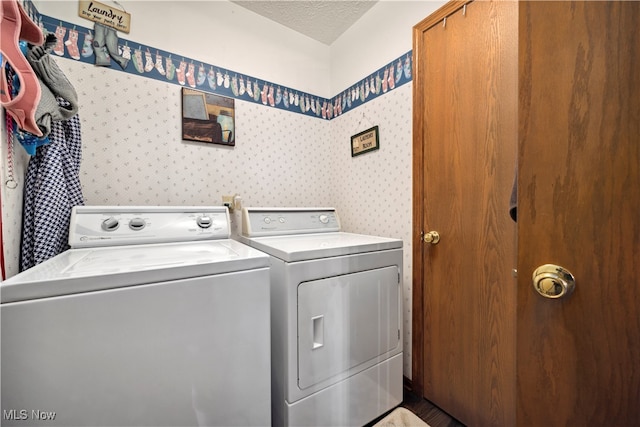 laundry room with washing machine and clothes dryer and a textured ceiling