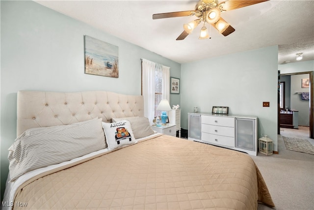 bedroom featuring a textured ceiling, carpet floors, and ceiling fan