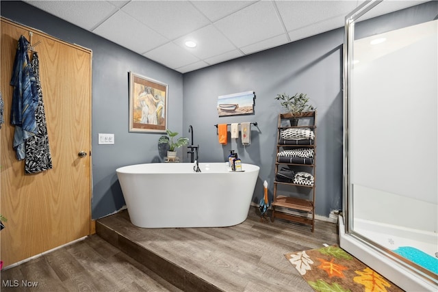 bathroom with a drop ceiling, hardwood / wood-style floors, and separate shower and tub