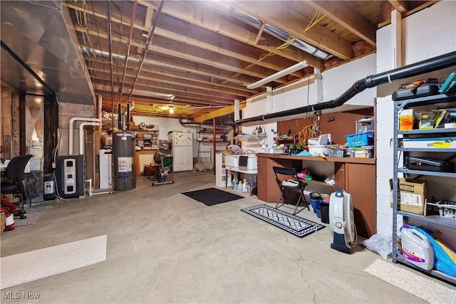 basement with water heater and white fridge