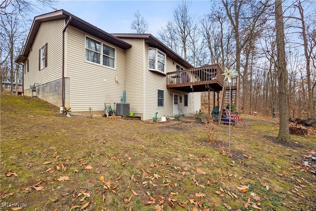 back of house with central air condition unit, a yard, and a wooden deck