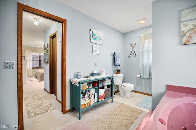 bathroom with a washtub, sink, and toilet