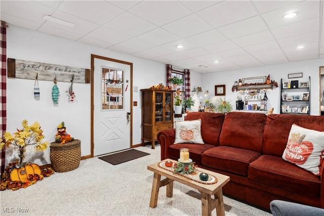 carpeted living room with a drop ceiling